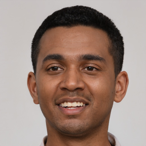 Joyful black young-adult male with short  black hair and brown eyes