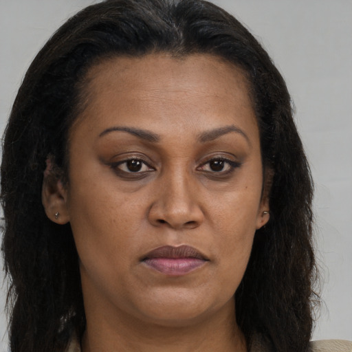 Joyful latino adult female with long  brown hair and brown eyes