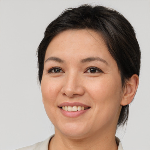Joyful asian adult female with medium  brown hair and brown eyes