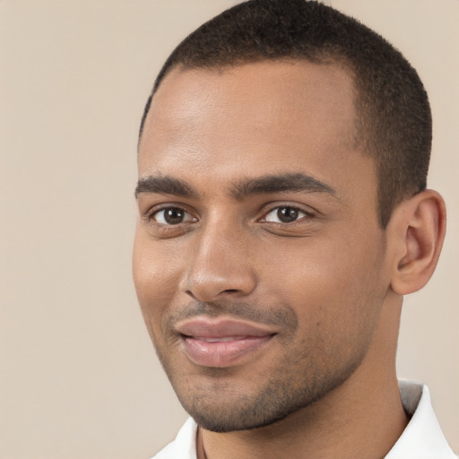 Joyful black young-adult male with short  brown hair and brown eyes