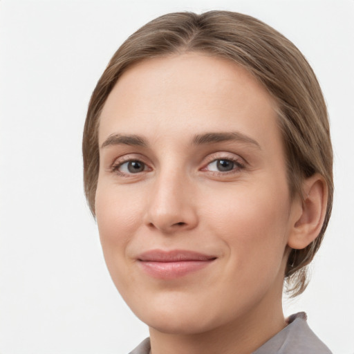 Joyful white young-adult female with medium  brown hair and grey eyes