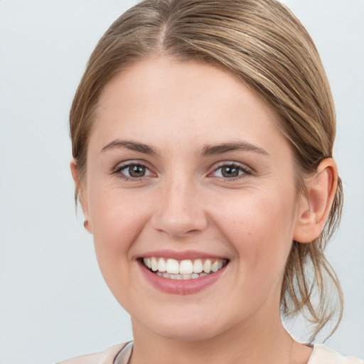 Joyful white young-adult female with medium  brown hair and grey eyes