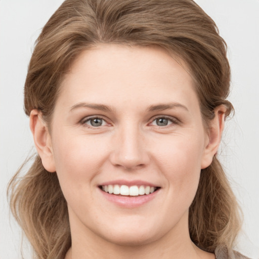 Joyful white young-adult female with medium  brown hair and grey eyes