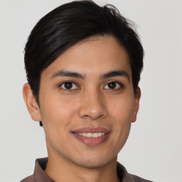 Joyful latino young-adult male with short  brown hair and brown eyes