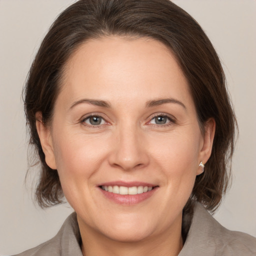 Joyful white adult female with medium  brown hair and brown eyes