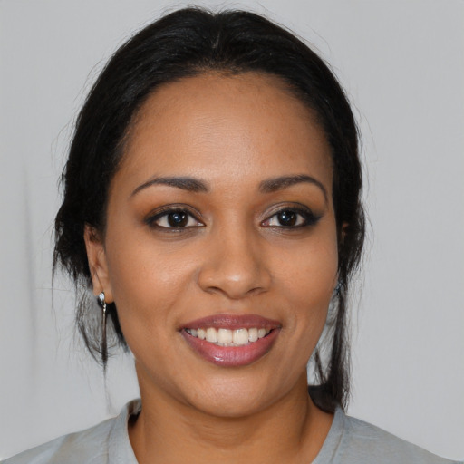 Joyful black young-adult female with medium  black hair and brown eyes