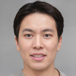 Joyful asian young-adult male with short  brown hair and brown eyes