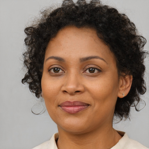 Joyful black adult female with medium  brown hair and brown eyes