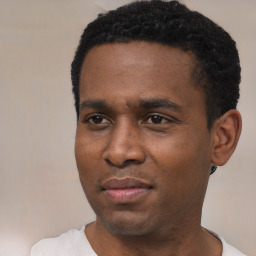 Joyful black young-adult male with short  black hair and brown eyes