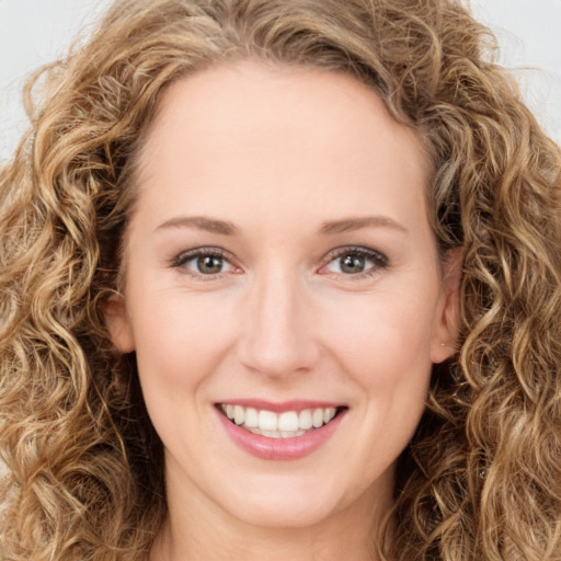 Joyful white young-adult female with long  brown hair and green eyes