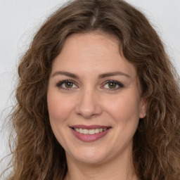 Joyful white young-adult female with long  brown hair and green eyes