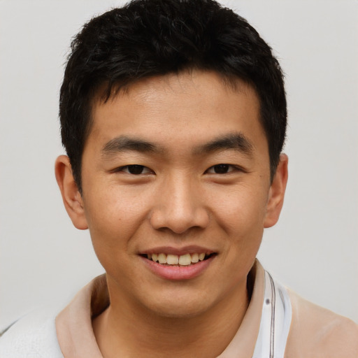 Joyful asian young-adult male with short  black hair and brown eyes