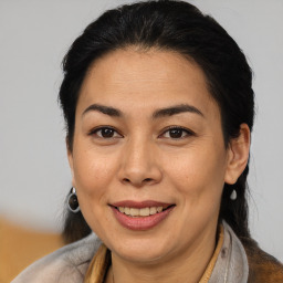 Joyful latino adult female with medium  brown hair and brown eyes