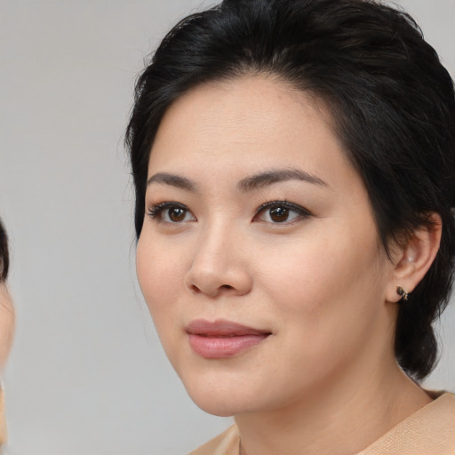 Joyful white young-adult female with medium  black hair and brown eyes