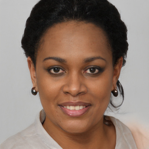 Joyful black young-adult female with short  black hair and brown eyes