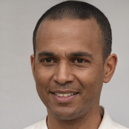 Joyful latino young-adult male with short  brown hair and brown eyes