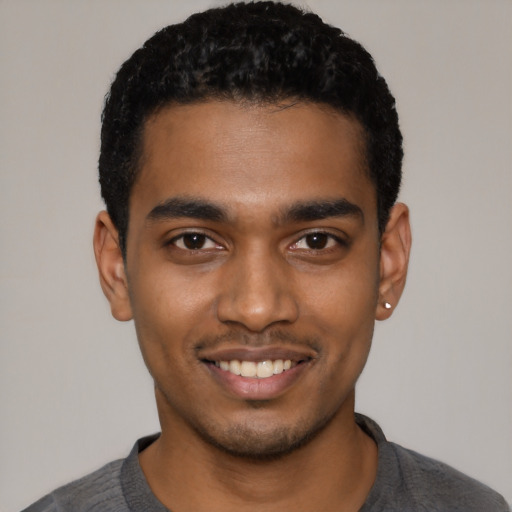 Joyful black young-adult male with short  black hair and brown eyes