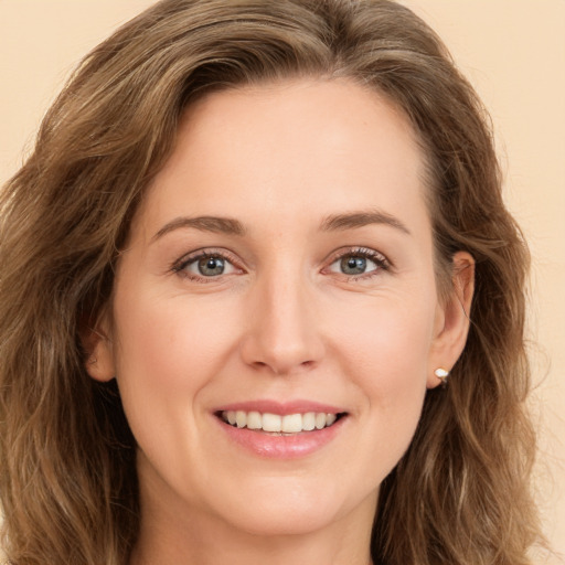 Joyful white young-adult female with long  brown hair and green eyes