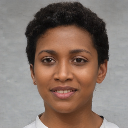Joyful black young-adult female with short  black hair and brown eyes