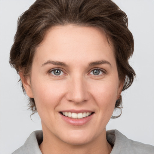 Joyful white young-adult female with medium  brown hair and grey eyes