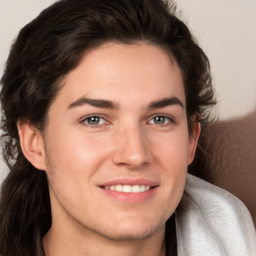 Joyful white young-adult male with long  brown hair and brown eyes