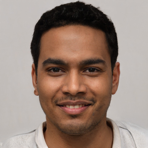 Joyful latino young-adult male with short  black hair and brown eyes