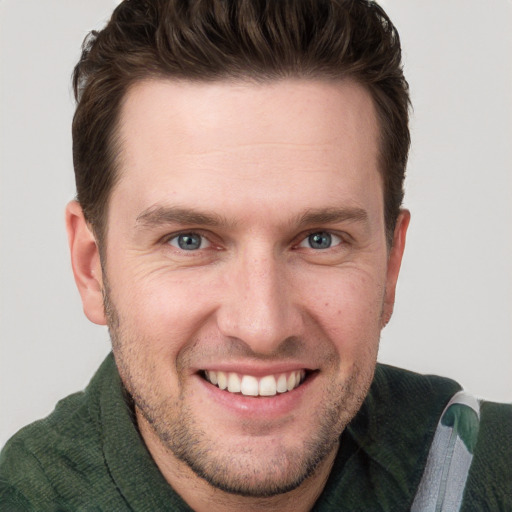 Joyful white young-adult male with short  brown hair and blue eyes