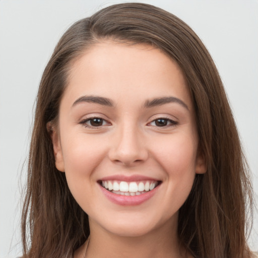 Joyful white young-adult female with long  brown hair and brown eyes