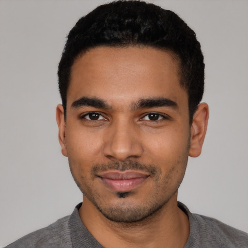 Joyful latino young-adult male with short  black hair and brown eyes