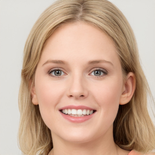 Joyful white young-adult female with long  brown hair and blue eyes