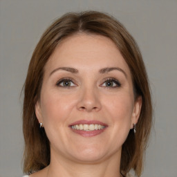 Joyful white adult female with medium  brown hair and grey eyes