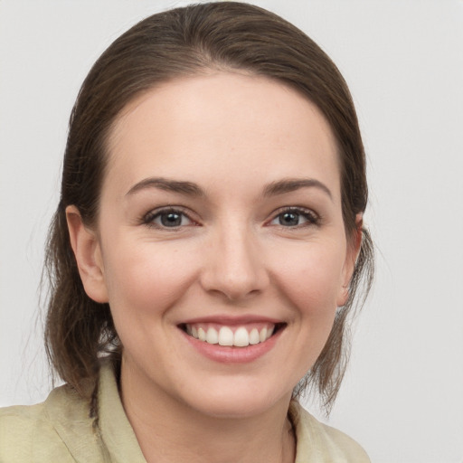 Joyful white young-adult female with medium  brown hair and grey eyes