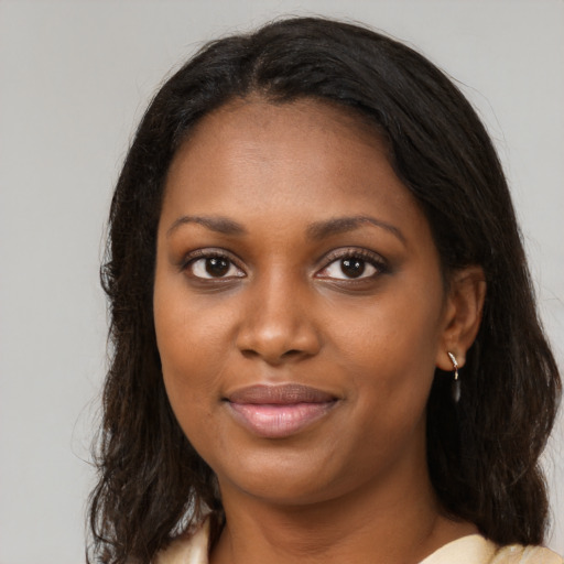 Joyful black young-adult female with long  brown hair and brown eyes