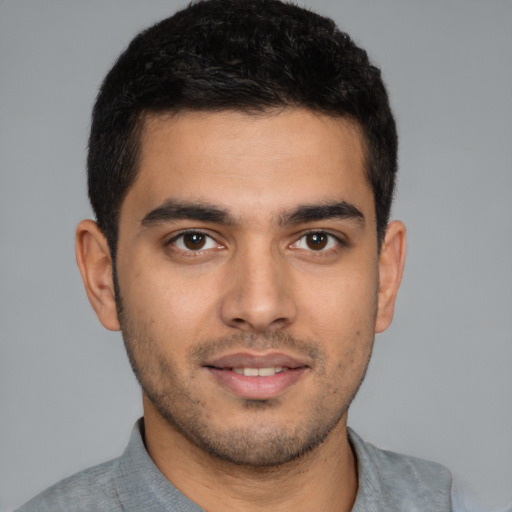 Joyful latino young-adult male with short  brown hair and brown eyes