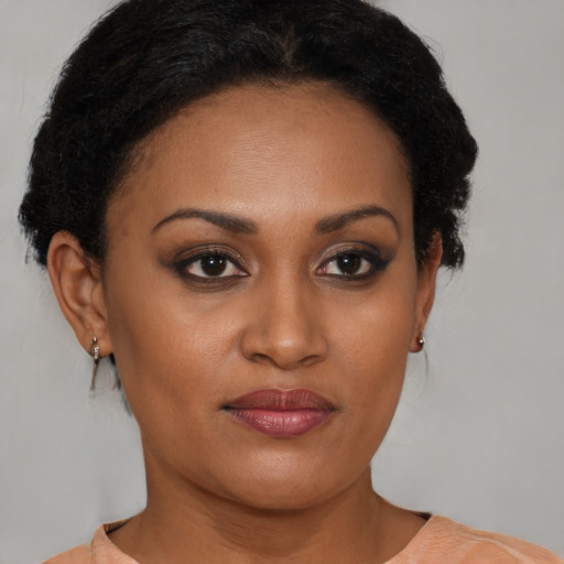 Joyful black young-adult female with short  brown hair and brown eyes