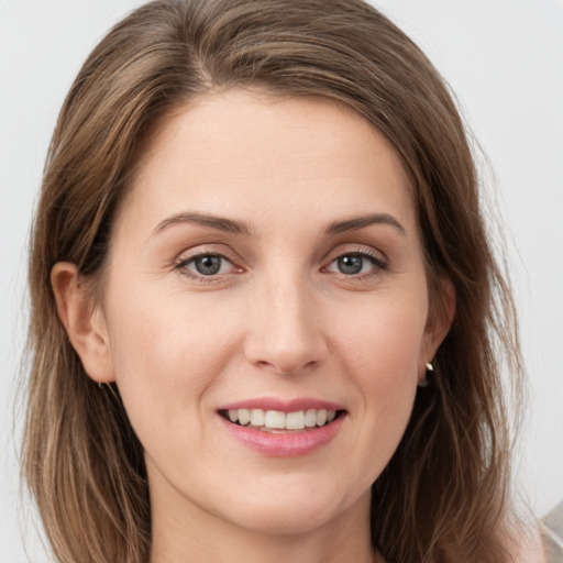 Joyful white young-adult female with medium  brown hair and grey eyes