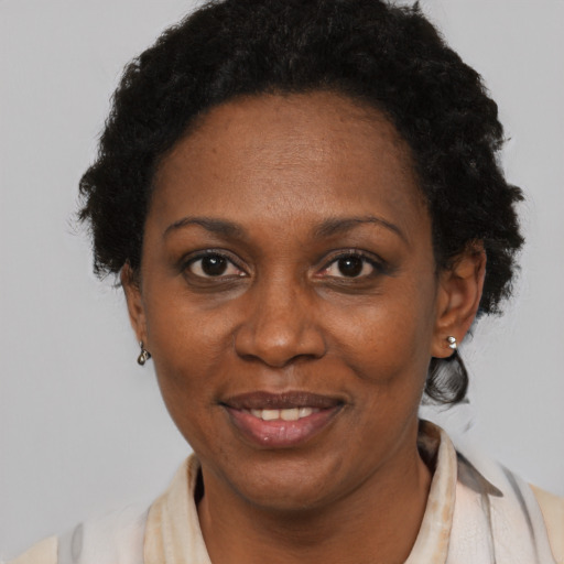 Joyful black adult female with short  black hair and brown eyes