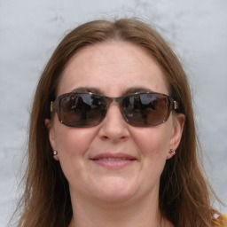 Joyful white adult female with medium  brown hair and blue eyes