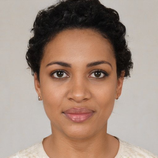 Joyful black young-adult female with short  black hair and brown eyes