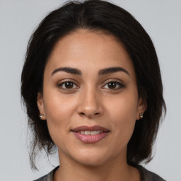 Joyful latino young-adult female with medium  brown hair and brown eyes