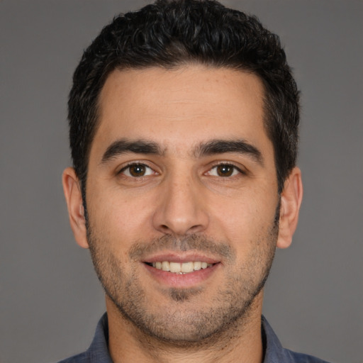 Joyful white young-adult male with short  black hair and brown eyes