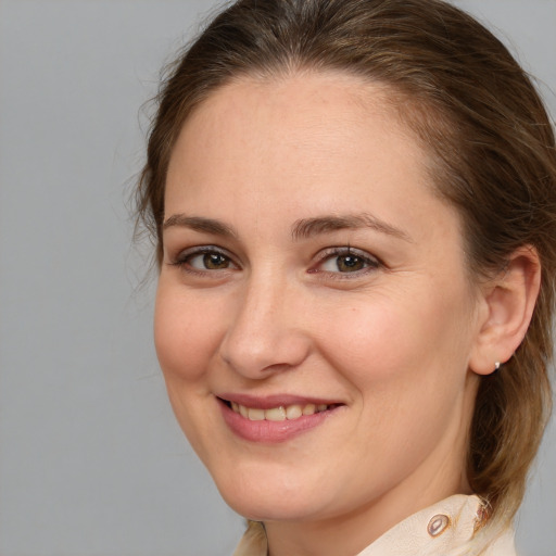 Joyful white young-adult female with medium  brown hair and grey eyes