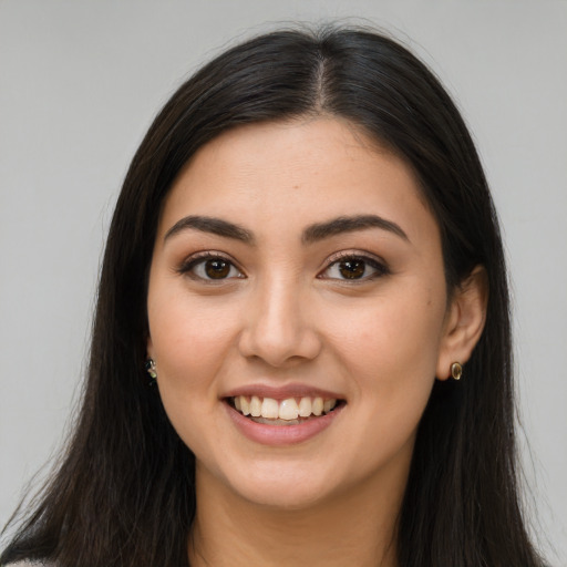Joyful latino young-adult female with long  brown hair and brown eyes