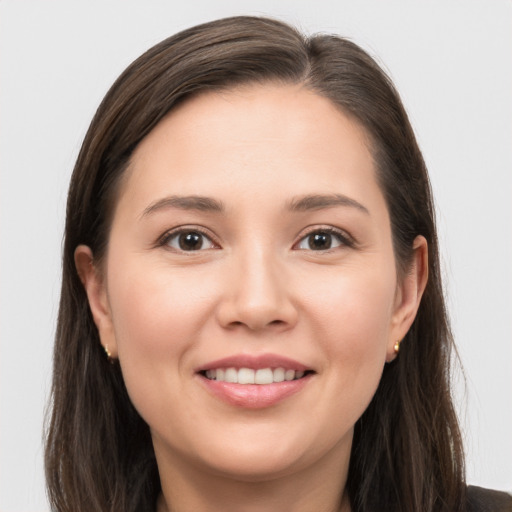 Joyful white young-adult female with long  brown hair and brown eyes