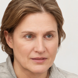 Joyful white adult female with medium  brown hair and blue eyes