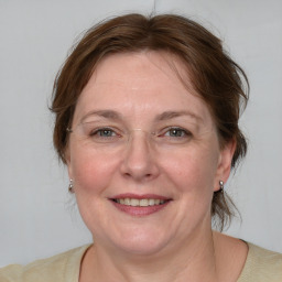 Joyful white adult female with medium  brown hair and blue eyes