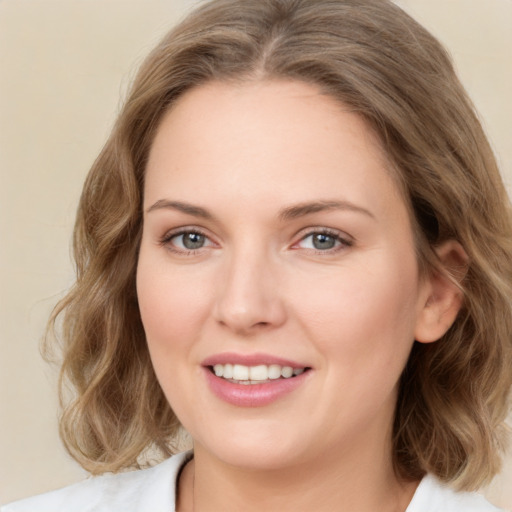 Joyful white young-adult female with medium  brown hair and green eyes