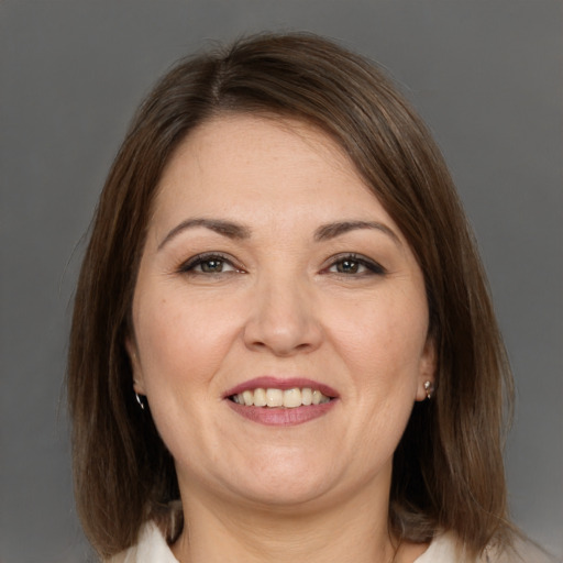 Joyful white adult female with medium  brown hair and brown eyes