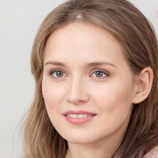 Joyful white young-adult female with long  brown hair and blue eyes