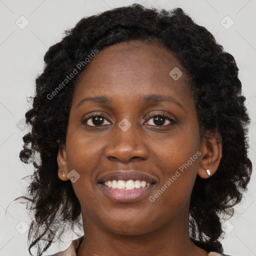 Joyful black young-adult female with long  brown hair and brown eyes